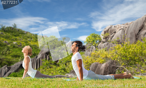 Image of couple making yoga cobra pose outdoors