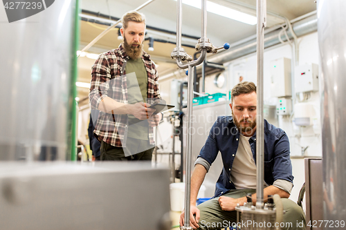 Image of men with tablet pc at craft beer brewery filter