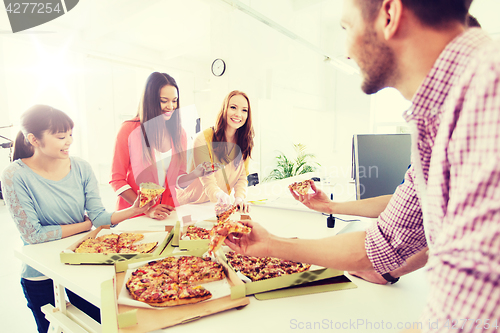 Image of happy business team eating pizza in office
