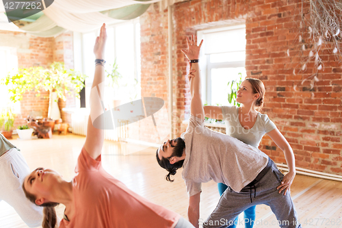 Image of group of people doing yoga exercises at studio