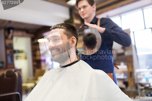 Image of man and hairdresser with mirror at barbershop