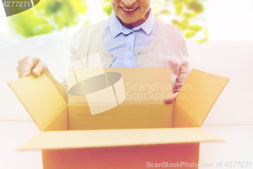 Image of close up of senior woman with parcel box at home