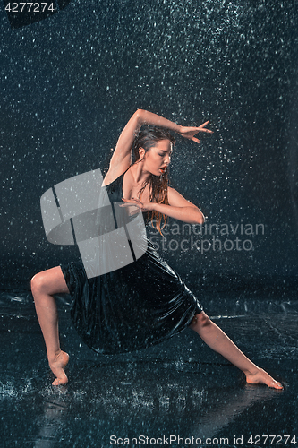 Image of The young beautiful modern dancer dancing under water drops