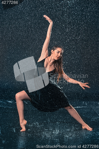 Image of The young beautiful modern dancer dancing under water drops