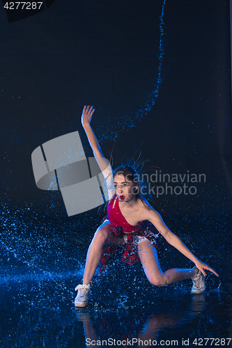Image of The young beautiful modern dancer dancing under water drops