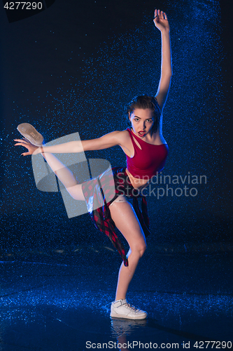 Image of The young beautiful modern dancer dancing under water drops