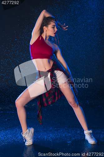 Image of The young beautiful modern dancer dancing under water drops