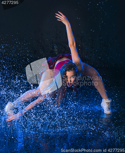 Image of The young beautiful modern dancer dancing under water drops