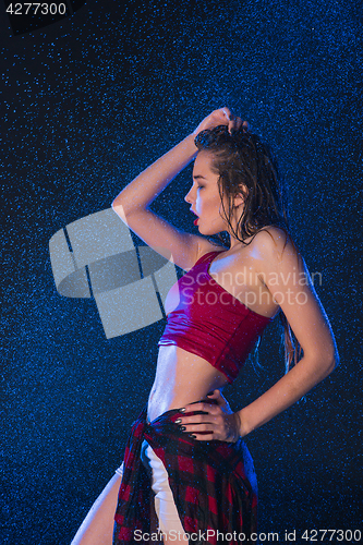 Image of The young beautiful modern dancer dancing under water drops