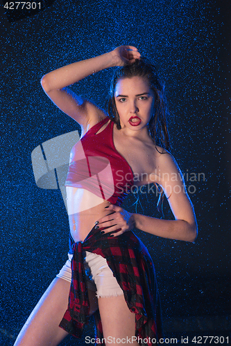 Image of The young beautiful modern dancer dancing under water drops