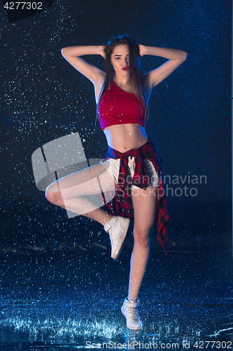 Image of The young beautiful modern dancer dancing under water drops