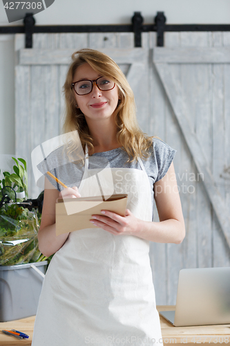 Image of Young woman florist with glasses