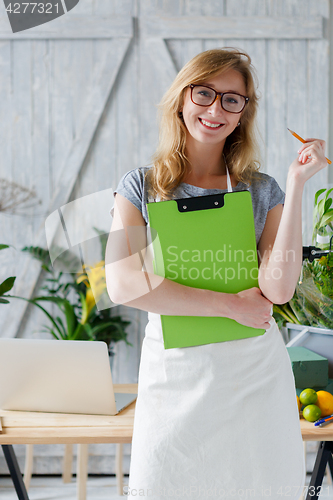 Image of Smiling woman florist with glasses