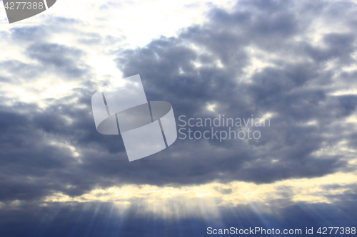 Image of dark evening clouds and beams of sun