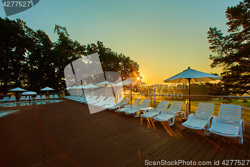 Image of Relaxing chairs beside swimming pool