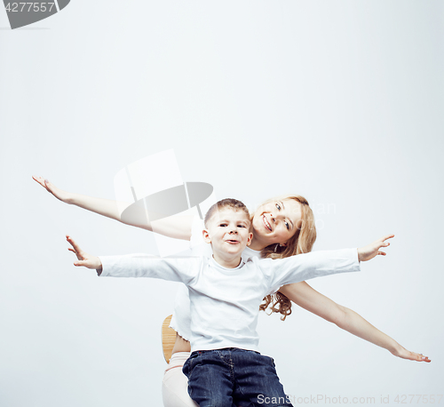 Image of young modern blond curly mother with cute son together happy smiling family posing cheerful on white background, lifestyle people concept, sister and brother friends 