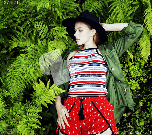 Image of Pretty young blond girl hipster in hat among fern, vacation in green forest, lifestyle fashion people concept