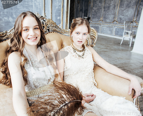 Image of two pretty twin sister blond curly hairstyle girl in luxury house interior together, rich young people concept 