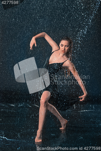 Image of The young beautiful modern dancer dancing under water drops