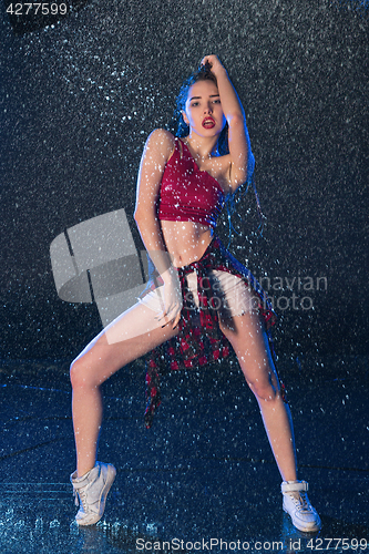 Image of The young beautiful modern dancer dancing under water drops