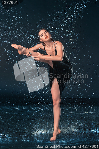 Image of The young beautiful modern dancer dancing under water drops