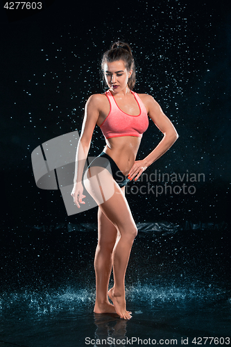 Image of Young tanned fit woman with beautiful sporty buttocks and slim with water drops