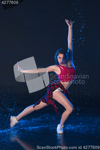 Image of The young beautiful modern dancer dancing under water drops