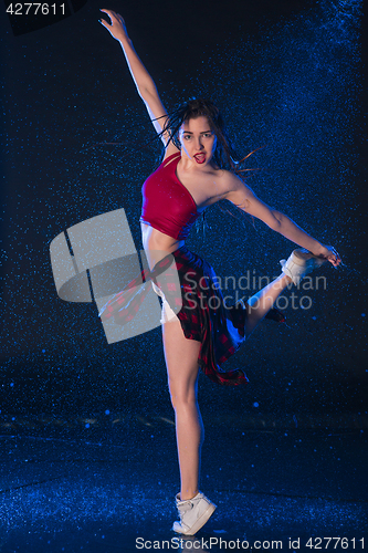 Image of The young beautiful modern dancer dancing under water drops