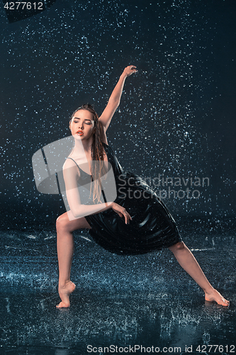 Image of The young beautiful modern dancer dancing under water drops