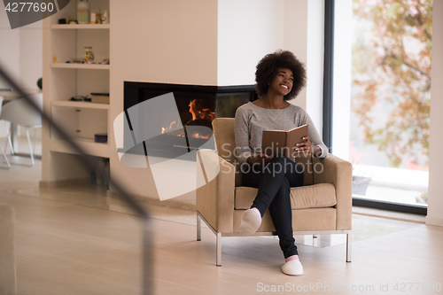 Image of black woman at home reading book
