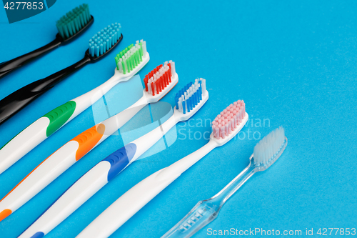 Image of Photo of seven multi-colored toothbrushes