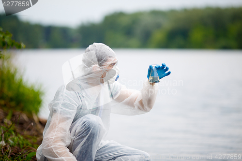 Image of Biologist with test-tube near river