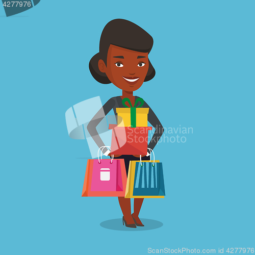 Image of Happy woman holding shopping bags and gift boxes.