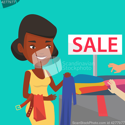 Image of Young woman choosing clothes in shop on sale.