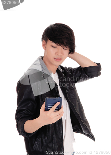 Image of Asian teenager looking at his cellphone.