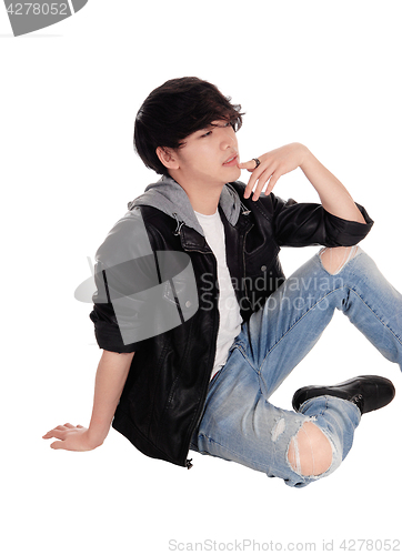 Image of Young Asian man sitting on floor.