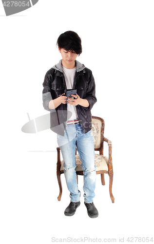 Image of Asian teenager looking at his cellphone.