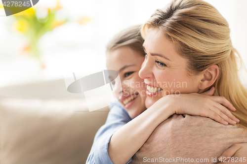 Image of happy smiling family hugging at home