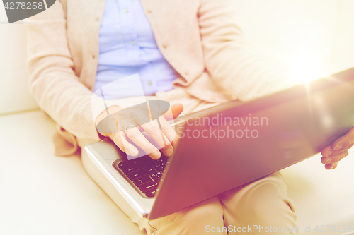 Image of close up of senior woman with laptop at home