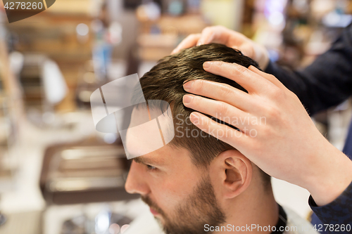 Image of man and barber styling hair at barbershop