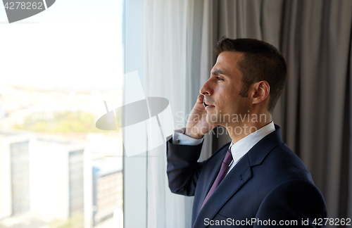 Image of businessman calling on smartphone at hotel room