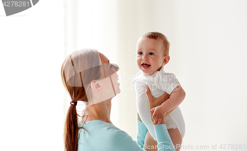 Image of happy young mother with little baby at home