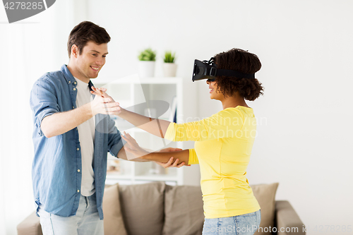 Image of happy couple with virtual reality headset at home