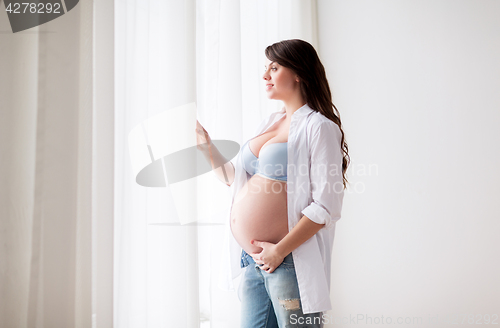 Image of happy pregnant woman with big tummy at home