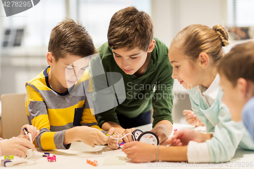 Image of happy children building robots at robotics school