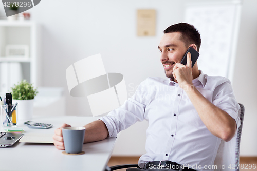 Image of businessman calling on smartphone at office