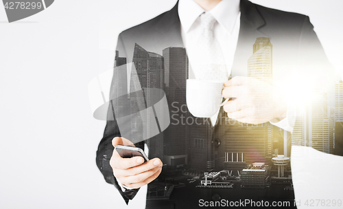 Image of businessman with smartphone and cup of coffee