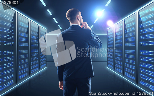 Image of businessman over server room background