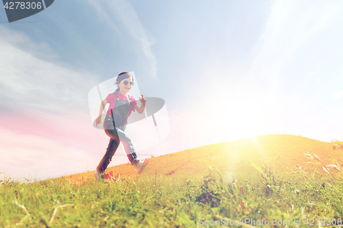 Image of happy little girl running on green summer field