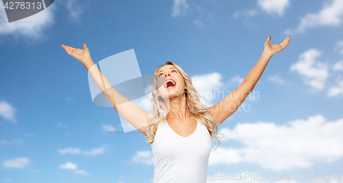 Image of happy woman celebrating victory over blue sky